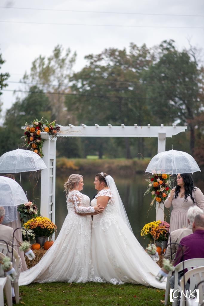 Two brides at outdoor fall wedding ceremony