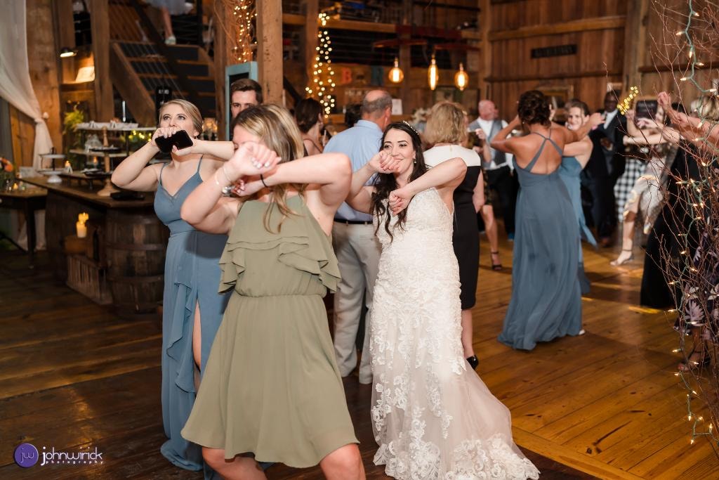 Bride and guests doing the Wobble at barn wedding