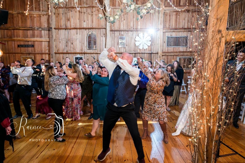 Groom dancing with bride at barn wedding