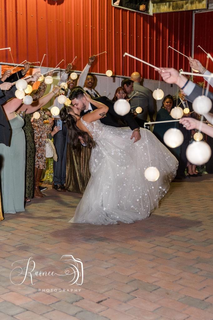 Couple dancing under hanging lanterns at wedding exit