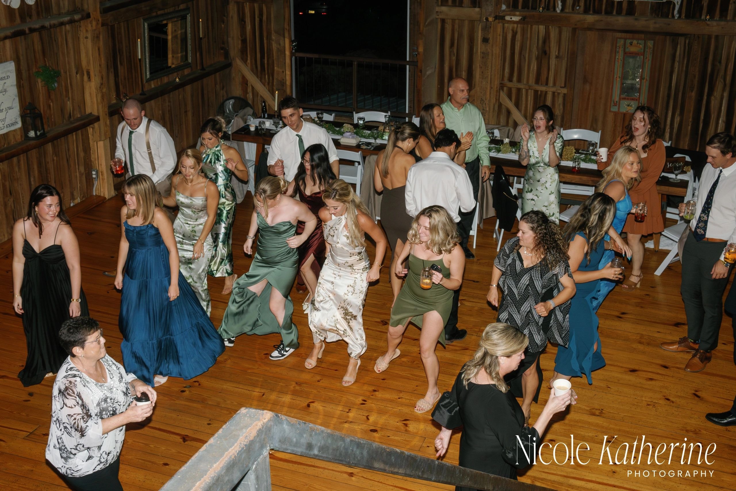 Guests dancing at rustic barn wedding reception